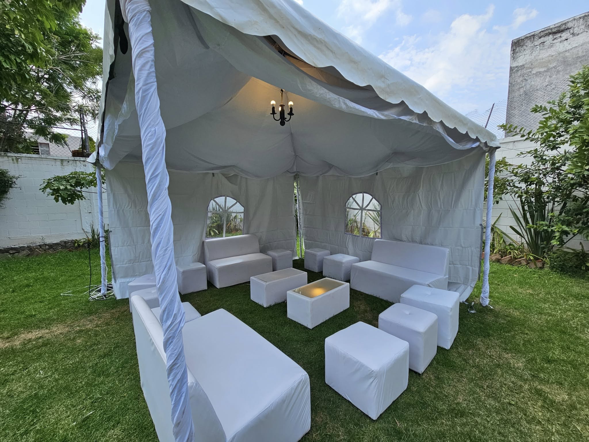 Zona lounge VIP con sofás blancos bajo carpa